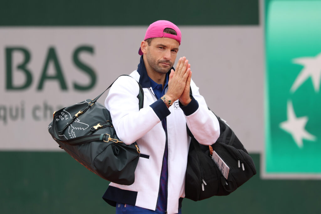 Grigor Dimitrov puts his hands together in apology