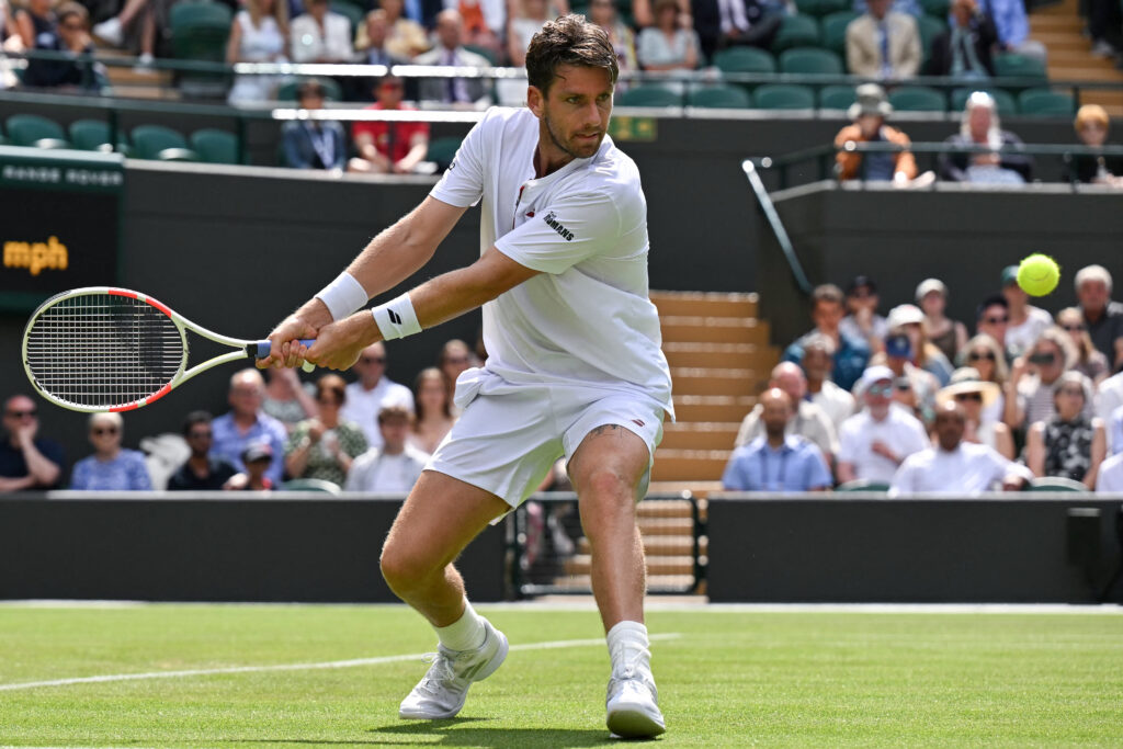 Britain's Cameron Norrie plays a backhand return to US player Frances Tiafoe during their men's singles second round tennis match on the third day of the 2025 Wimbledon Championships at The All England Lawn Tennis and Croquet Club in Wimbledon, southwest London, on July 2, 2025.