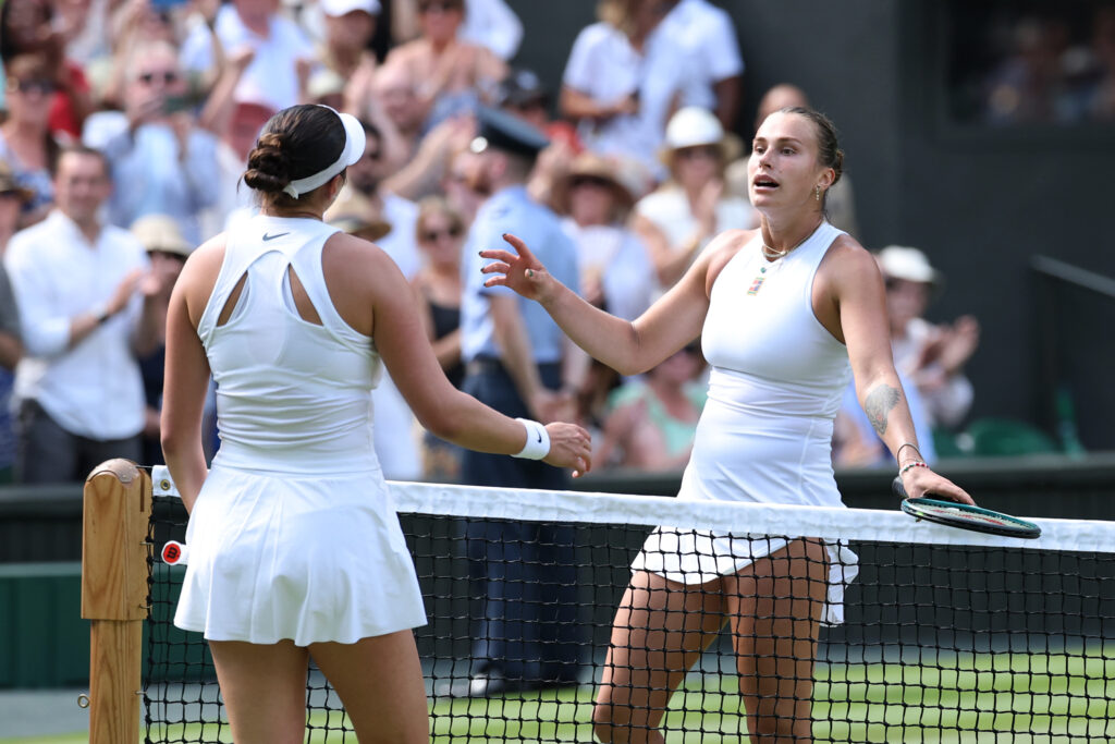 Amanda Anisimova and Aryna Sabalenka hug at the net