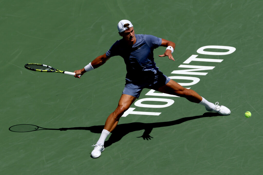 Holger Rune stretches to hit a forehand