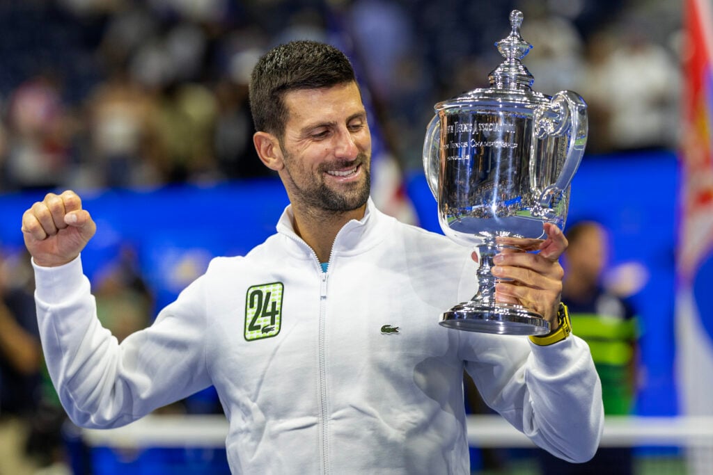 Novak Djokovic of Serbia with the winners' trophy and wearing a tracksuit representing his 24th grand slam win after his victory against Daniil Medvedev of Russia in the Men's Singles Final on Arthur Ashe Stadium during the US Open Tennis Championship 2023 at the USTA National Tennis Centre on September 10th, 2023 in Flushing, Queens, New York City.