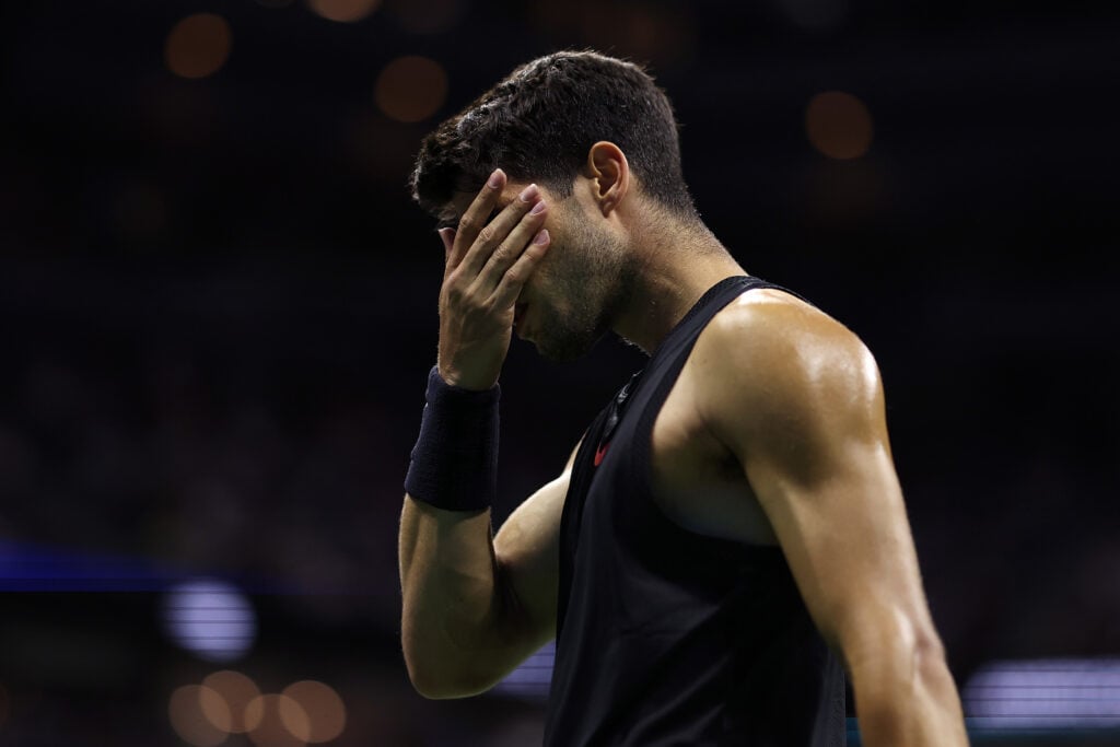 Carlos Alcaraz covers his face with his hand