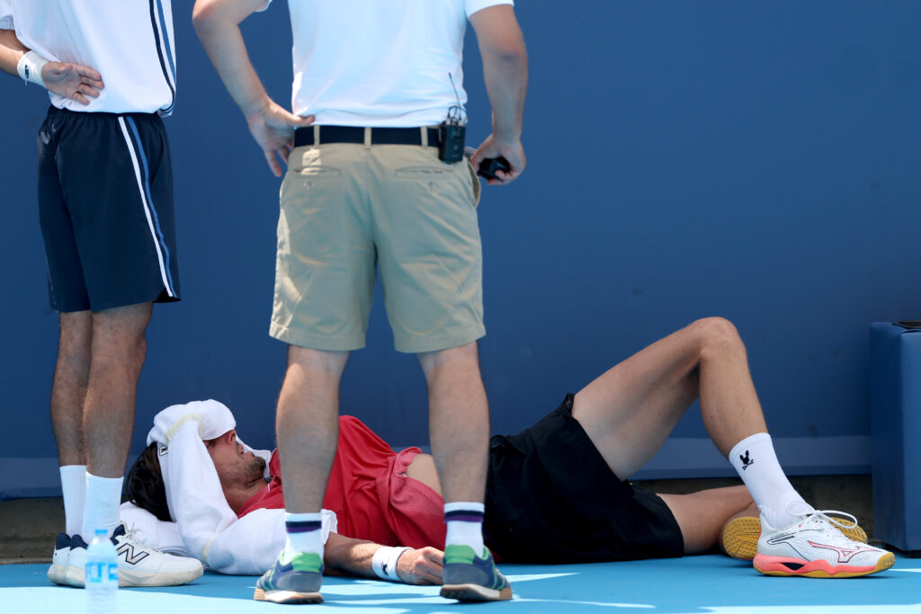 Arthur Rinderknech of France rests on the court for medical attention in his match against Felix Auger-Aliassime of Canada during the Cincinnati Open at Lindner Family Tennis Center on August 11, 2025 in Mason, Ohio.