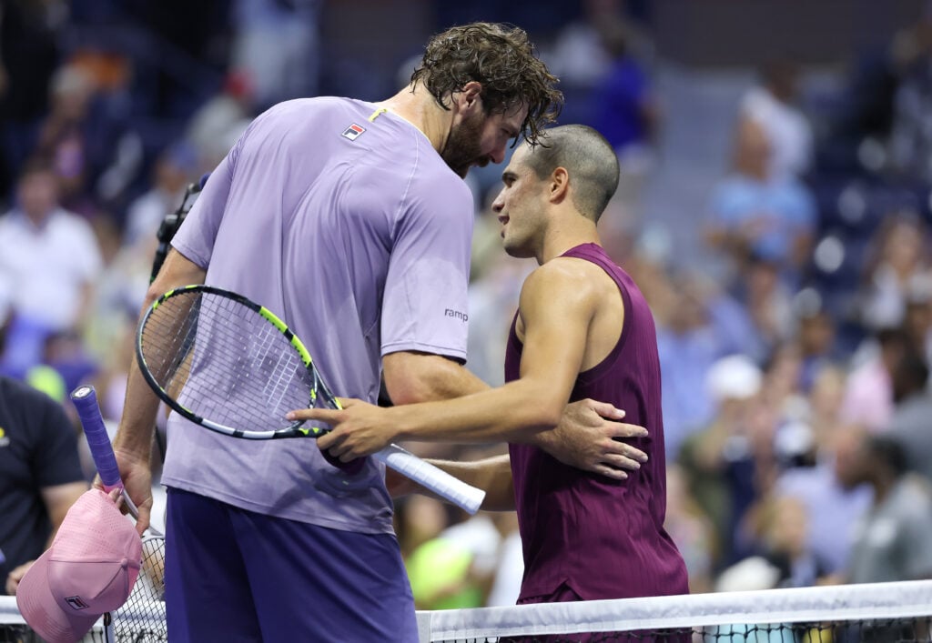 Carlos Alcaraz of Spain (R) greets Reilly Opelka of the United States following their Men's Singles First Round match on Day Two of the 2025 US Open at USTA Billie Jean King National Tennis Center on August 25, 2025 in the Flushing neighborhood of the Queens borough of New York City.
