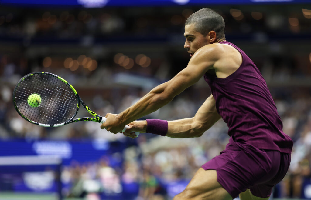 Carlos Alcaraz of Spain plays a backhand against Reilly Opelka of the United States during their Men's Singles First Round match on Day Two of the 2025 US Open at USTA Billie Jean King National Tennis Center on August 25, 2025 in the Flushing neighborhood of the Queens borough of New York City.