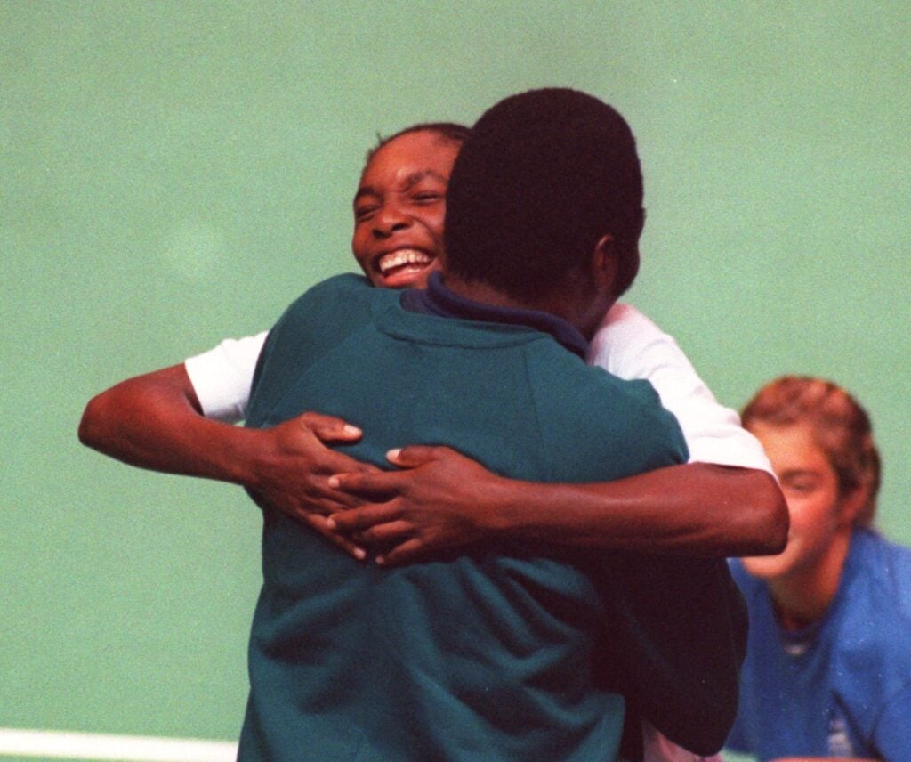VENUS WILLIMS, 14, HUGS HER FATHER, RICHARD, AFTER COMPLETING HER TOUR DEBUT IN THE BANK OF THE WEST CLASSIC IN OAKLAND, CALIFORNIA. WILLIAMS LOST TO TOP SEEDED ANRANTXA SANCHEZ-VICARIO, 2-6, 6-3, 6-0.