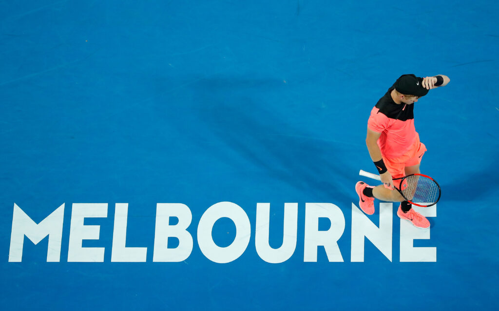Kyle Edmund walks over the Melbourne sign on the court
