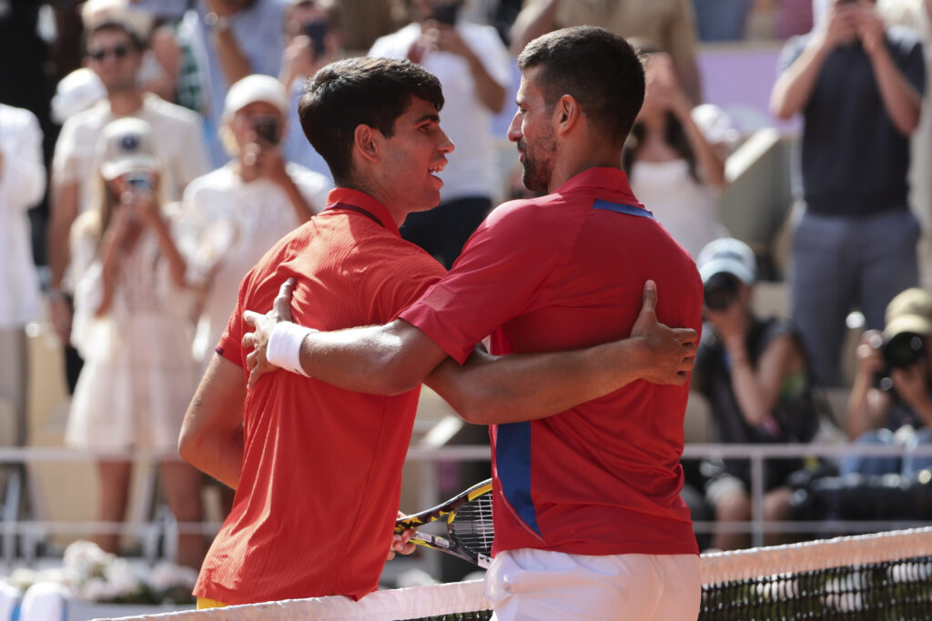 Carlos Alcaraz and Novak Djokovic hug at the net