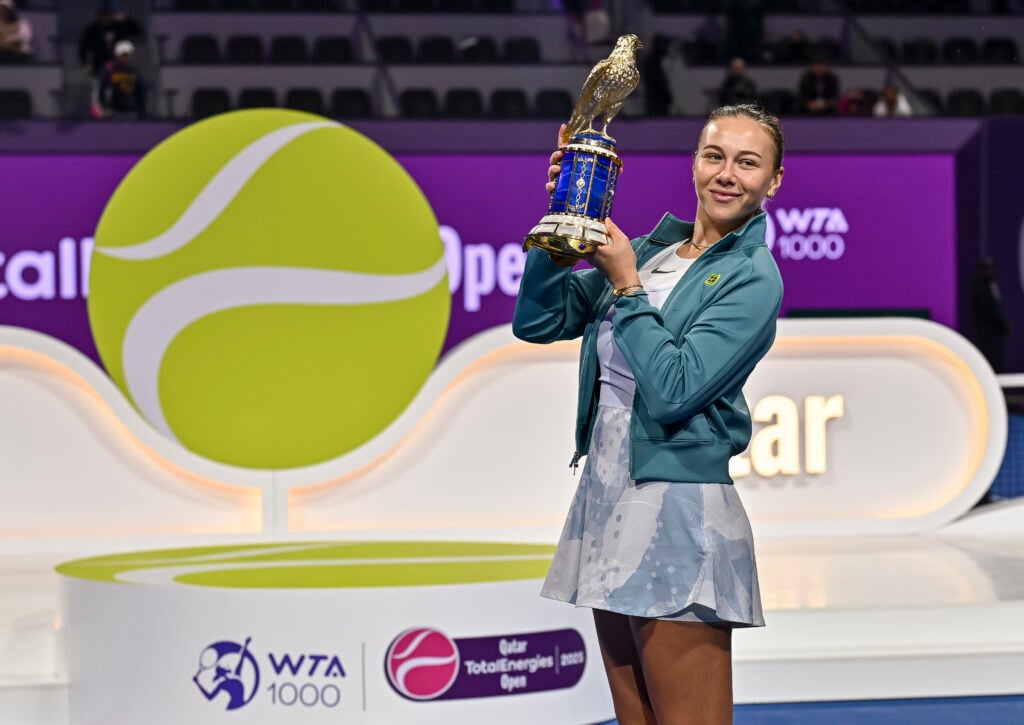 Amanda Anisimova holds his Qatar Open trophy up