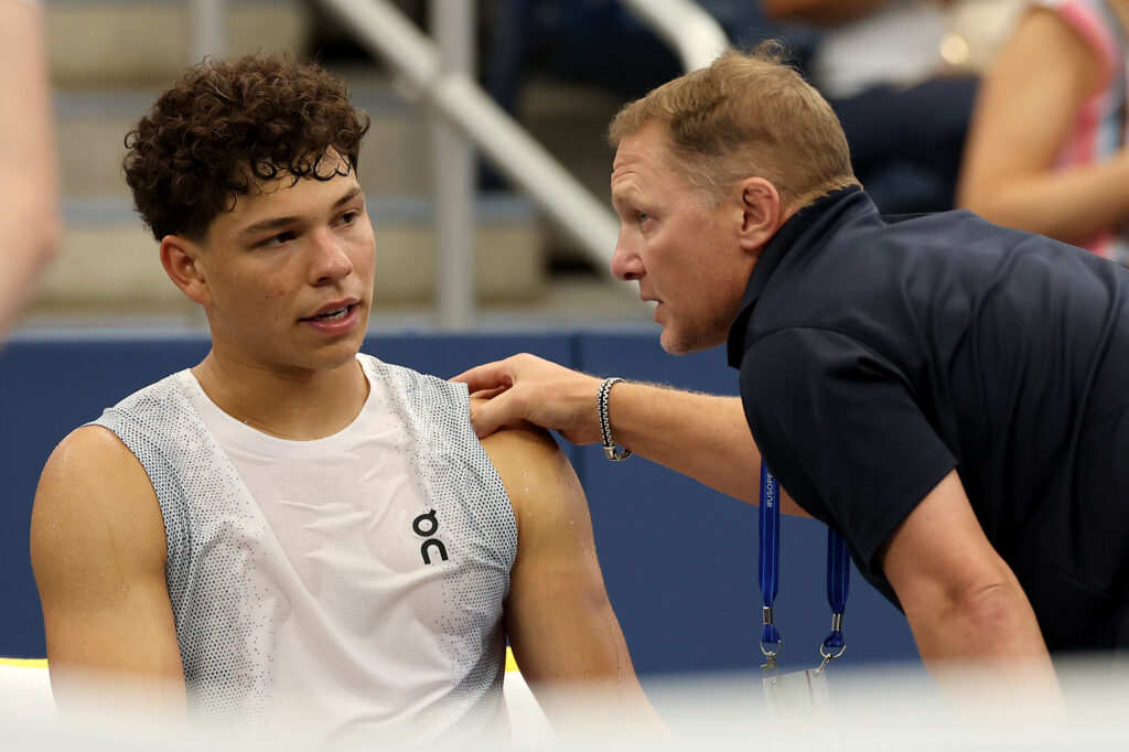 Ben Shelton of the United States receives medical treatment between games in the fourth set against Adrian Mannarino of France during their Men's Singles Third Round match on Day Six of the 2025 US Open at USTA Billie Jean King National Tennis Center on August 29, 2025 in the Flushing neighborhood of the Queens borough of New York City.