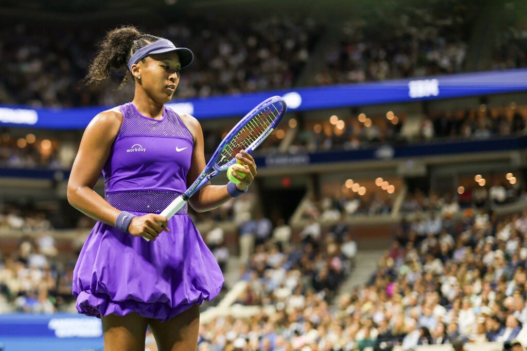 Naomi Osaka looks at her racket