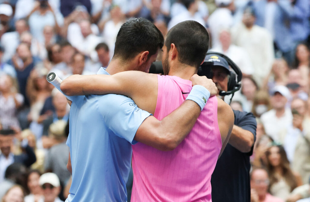 Novak Djokovic and Carlos Alcaraz embrace at the net