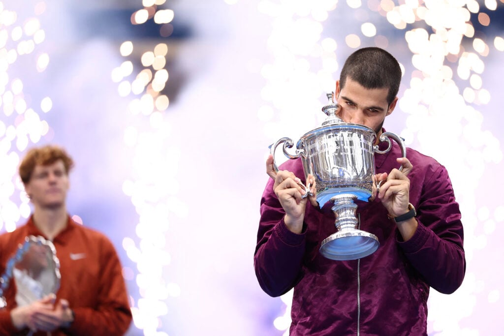 Spain's Carlos Alcaraz (R) celebrates with his trophy winning over Italy's Jannik Sinner during their men's singles final tennis match on day fifteen of the US Open tennis tournament at the USTA Billie Jean King National Tennis Center in New York City, on September 7, 2025.