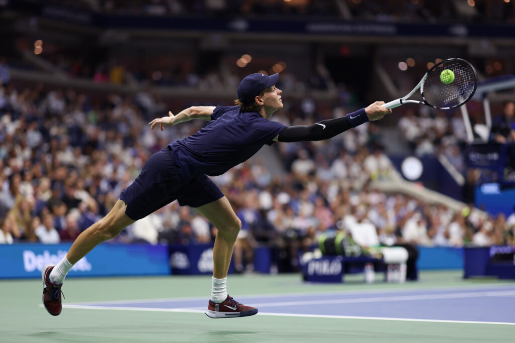 Jannik Sinner stretches for a forehand