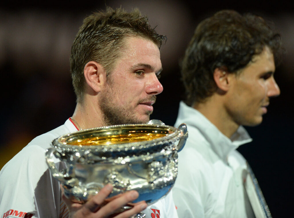 Switzerland's Stanislas Wawrinka (L) holds the trophy as he celebrates after victory in his mens singles final match against Spain's Rafael Nadal (R) on day fourteen of the 2014 Australian Open tennis tournament in Melbourne on January 26, 2014.