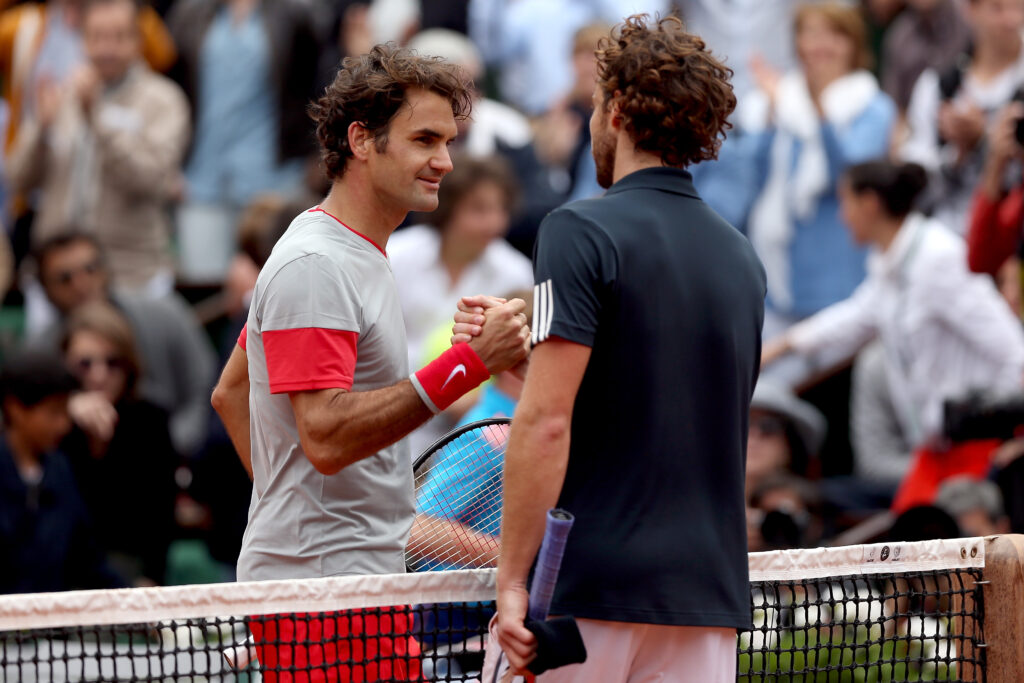Roger Federer and Ernest Gulbis shaking hands at the 2014 Roland Garros