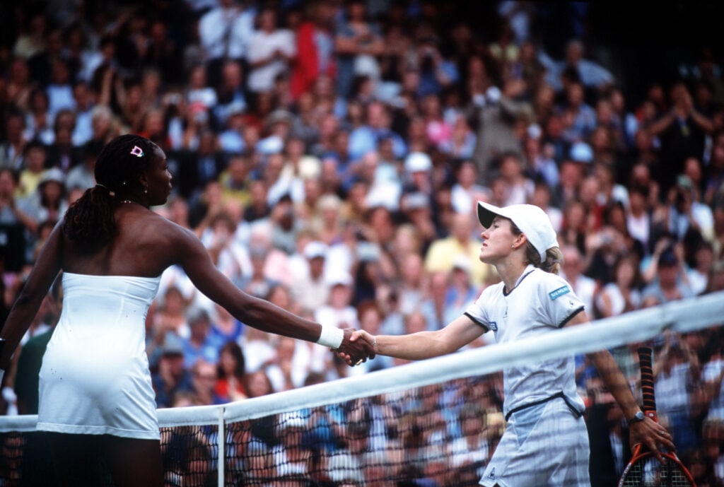 A happy Venus Williams of the USA shakes hands over the net after beating Justine Henin of Belgium during the women's final of The All England Lawn Tennis Championship at Wimbledon, London.