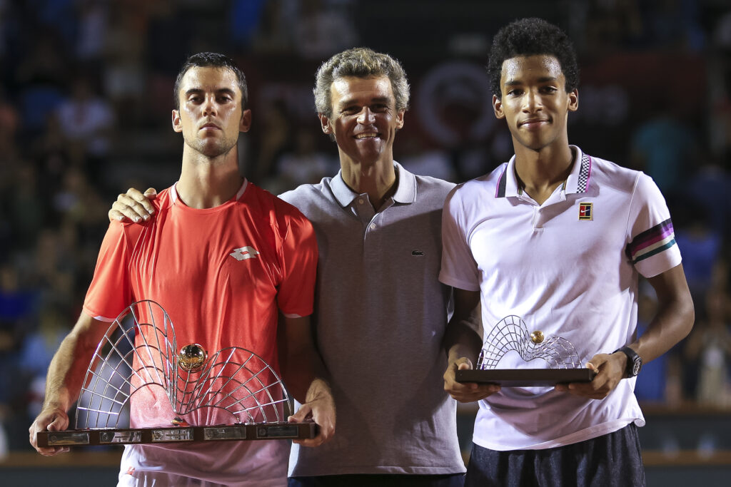 Laslo Djere of Serbia and Felix Auger-Aliassime of Canada pose with the former player Gustavo Kuerten on the podium after the singles final of the ATP Rio Open 2019 at Jockey Club Brasileiro on February 24, 2019 in Rio de Janeiro, Brazil.