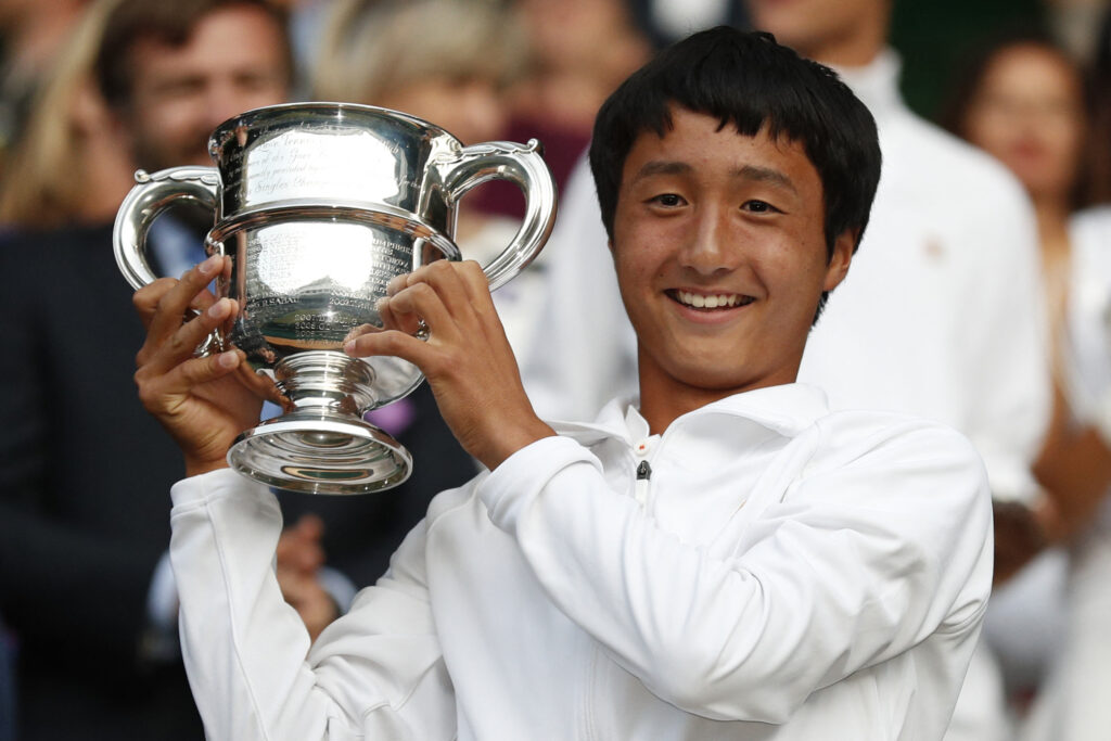 Japan's Shintaro Mochizuki raises the winner's trophy after beating Spain's Carlos Gimeno Valero during their boys' singles final on day thirteen of the 2019 Wimbledon Championships at The All England Lawn Tennis Club in Wimbledon, southwest London, on July 14, 2019.