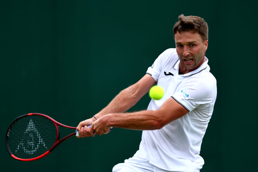 Liam Broady of Great Britain plays a backhand against Botic van De Zandschulp of Netherlands in the Gentlemen's Singles first round match during day one of The Championships Wimbledon 2024 at All England Lawn Tennis and Croquet Club on July 01, 2024 in London, England.