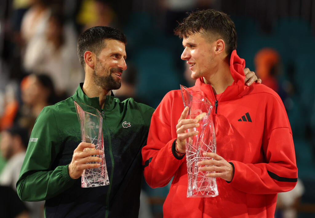 Jakub Mensik of the Czech Republic talks with Novak Djokovic of Serbia after winning the men's singles final on the final day of the Miami Open Presented by Itau 2025 at Hard Rock Stadium on March 30, 2025 in Miami Gardens, Florida.