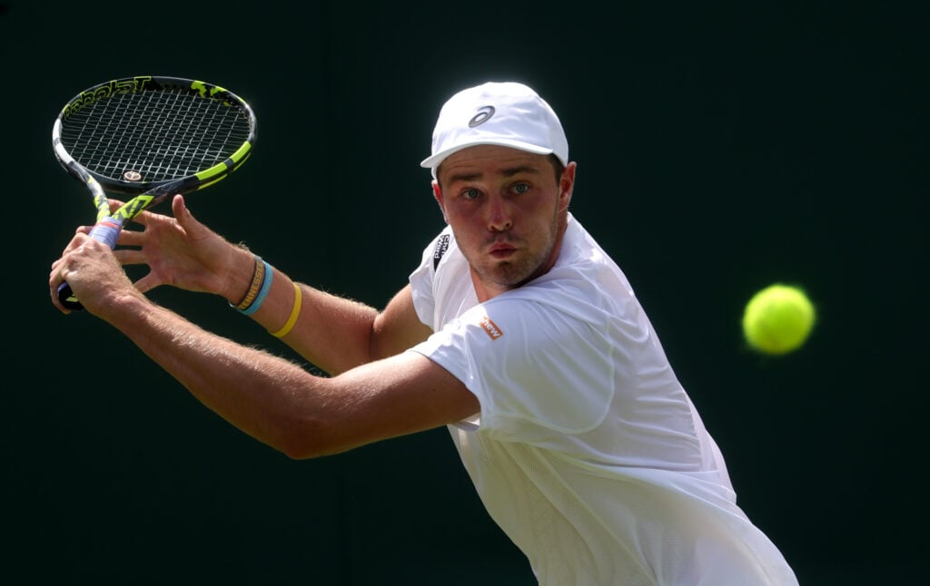 Johannus Monday of Great Britain plays a backhand against Tommy Paul of United States during the Gentlemen's Singles first round match on day two of The Championships Wimbledon 2025 at All England Lawn Tennis and Croquet Club on July 01, 2025 in London, England.