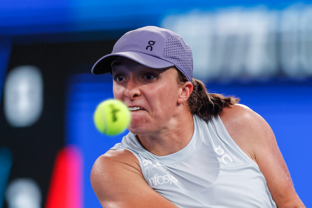 Iga Świątek of Poland returns a shot against Belinda Bencic of Switzerland in the Women's Singles Round of 16 match during day six of the 2025 Wuhan Open at Optics Valley International Tennis Center on October 9, 2025 in Wuhan, China.