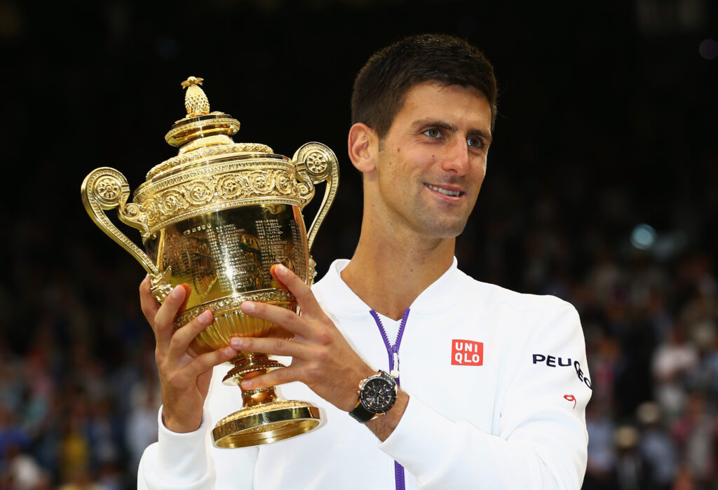 Novak Djokovic of Serbia celebrates with the trophy after winning the Final Of The Gentlemen's Singles against Roger Federer of Switzerland on day thirteen of the Wimbledon Lawn Tennis Championships at the All England Lawn Tennis and Croquet Club on July 12, 2015 in London, England.