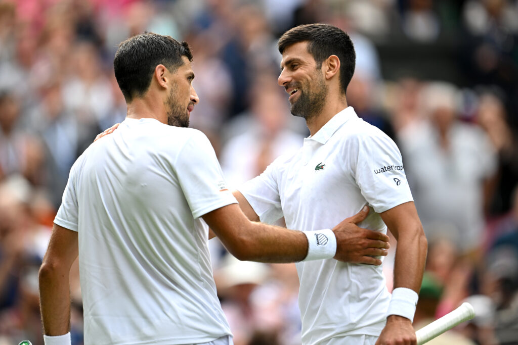 Novak Djokovic (R) of Serbia interacts with Pedro Cachin of Argentina following the Men's Singles first round match on day one of The Championships Wimbledon 2023 at All England Lawn Tennis and Croquet Club on July 03, 2023 in London, England.
