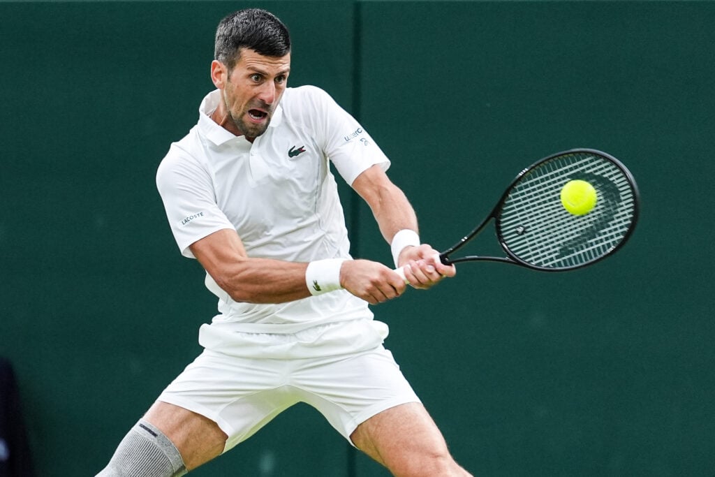 Novak Djokovic of Serbia plays a backhand in the Men's Singles third round match against Alexei Popyrin of Australia during day six of The Championships Wimbledon 2024