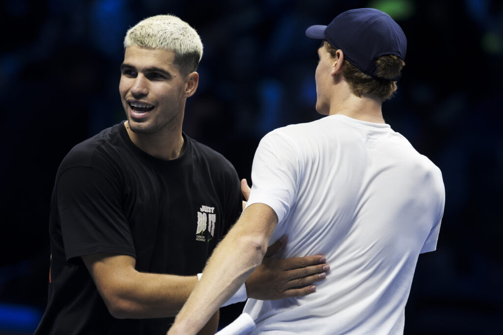 Carlos Alcaraz (L) of Spain hugs Jannik Sinner of Italy at the end of their practice during the Nitto ATP Finals 2025.