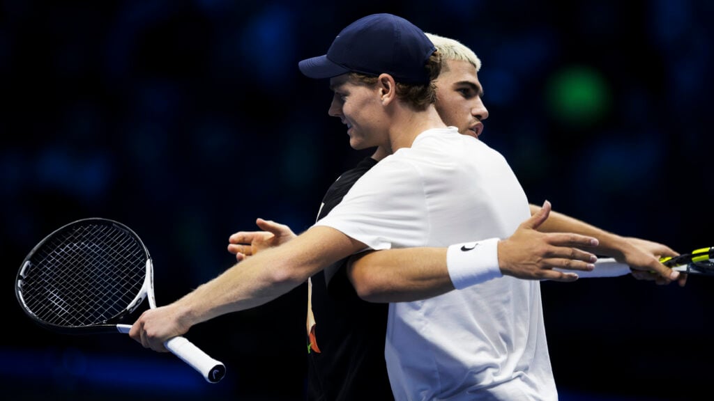 Jannik Sinner (L) of Italy hugs Carlos Alcaraz of Spain at the end of their practice during the Nitto ATP Finals 2025.