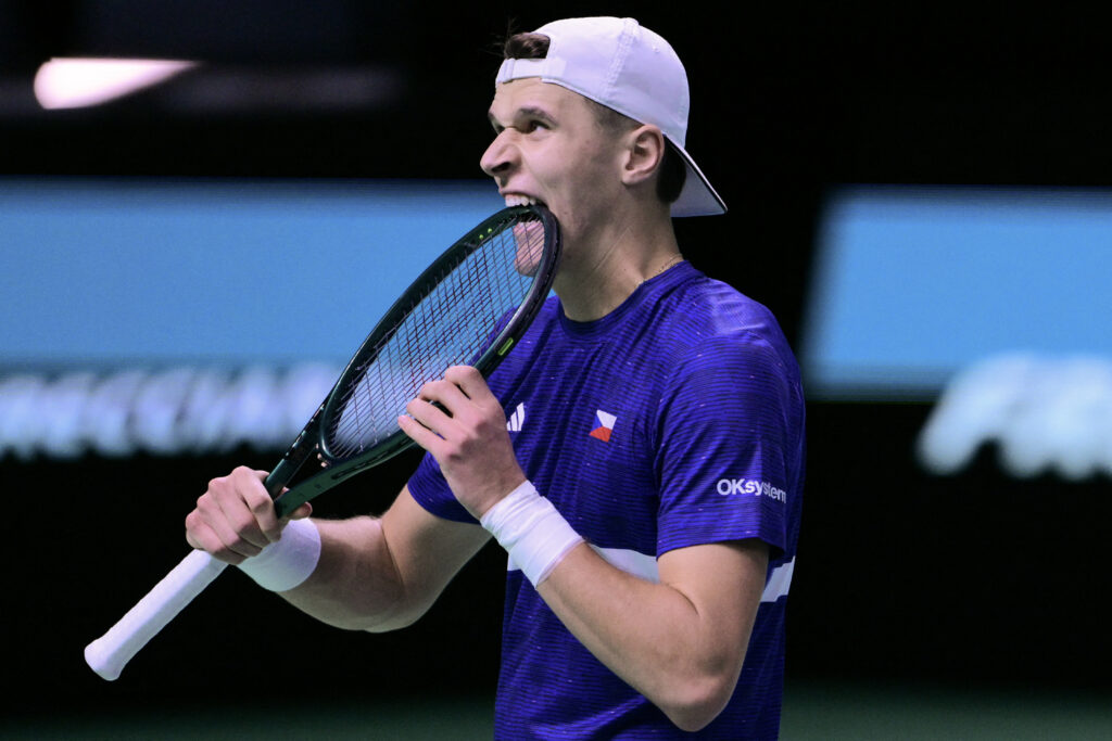 Czech Republic's Jakub Mensik bites his racket as he react as he plays against Spain's Pedro Martinez Portero and Spain's Marcel Granollers-Pujol during their Davis Cup men's doubles quarter finals tennis match, at the Super Tennis Arena, in Bologna.