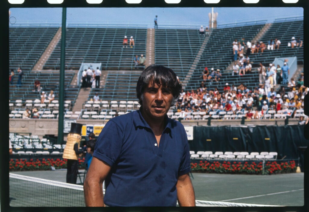 Close up of tennis star Pancho Gonzalez of Mexico, standing on a tennis court.
