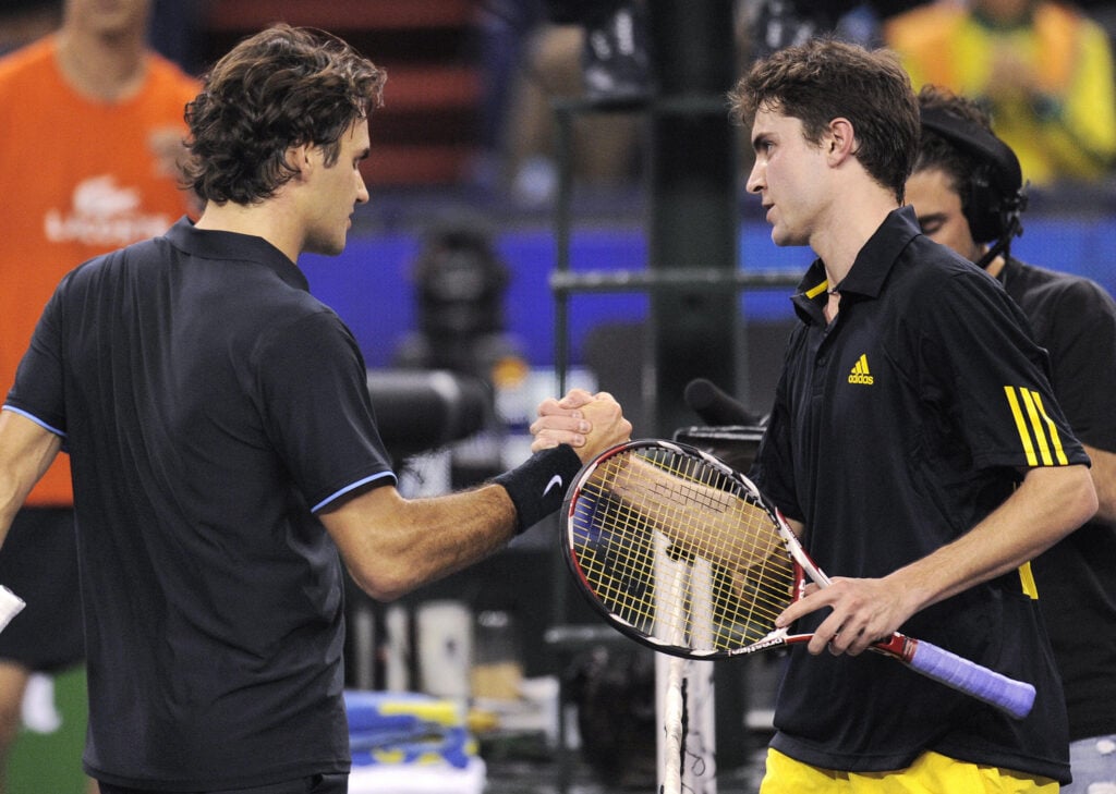 Gilles Simon (R) of France shakes hands with Roger Federer of Switzerland at the end of their singles match on the second day of the ATP Masters Cup tennis tournament in Shanghai on November 10, 2008. Simon upset the world number two 4-6, 6-4, 6-3.