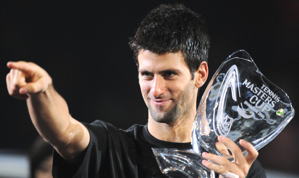 Novak Djokovic of Serbia points to his girlfriend in the stands as he holds the winner's trophy following his victory over Nikolay Davydenko of Russia in the men's singles final at the ATP Masters Cup tennis tournament in Shanghai on November 16, 2008. Djokovic won 6-1, 7-5 to take the title.
