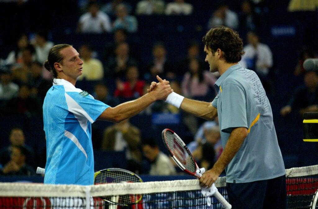 Roger Federer (R) and David Nalbandian shake hands after their first round match at the Tennis Masters Cup in Shanghai, China on November 12, 2006. Federer defeated Nalbandian 3-6, 6-1, 6-1.