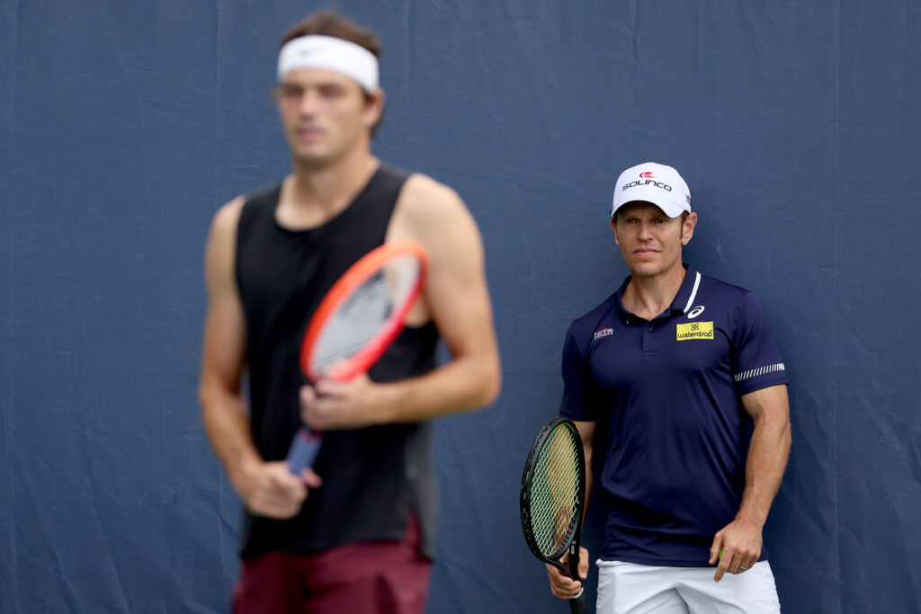 Michael Russell watches Taylor Fritz of United States train in preparation for the US Open at the USTA Billie Jean King National Tennis Center on August 24, 2023 in New York City.