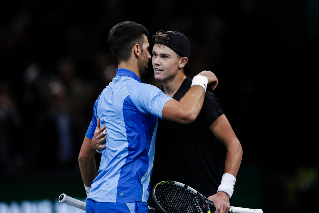 Novak Djokovic and Holger Rune hug at the net