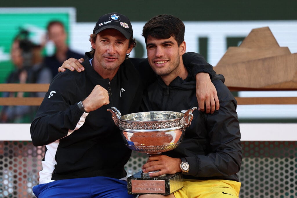 Spain's Carlos Alcaraz and his Spanish coach Juan Carlos Ferrero pose with the trophy after winning against Germany's Alexander Zverev in the men's singles final match on Court Philippe-Chatrier on day fifteen of the French Open tennis tournament at the Roland Garros Complex in Paris on June 9, 2024