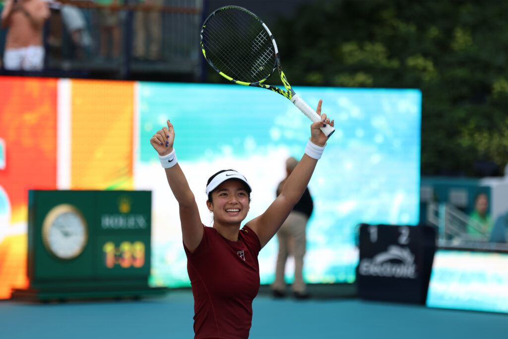 Alexandra Eala lifts her arms up in celebration