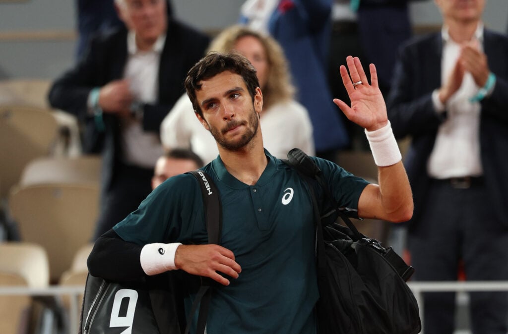 Lorenzo Musetti of Italy waves to the crowd as he leaves court after retiring injured from the Men's Singles Semi Final match against Carlos Alcaraz of Spain on Day Thirteen of the 2025 French Open at Roland Garros on June 06, 2025 in Paris, France.