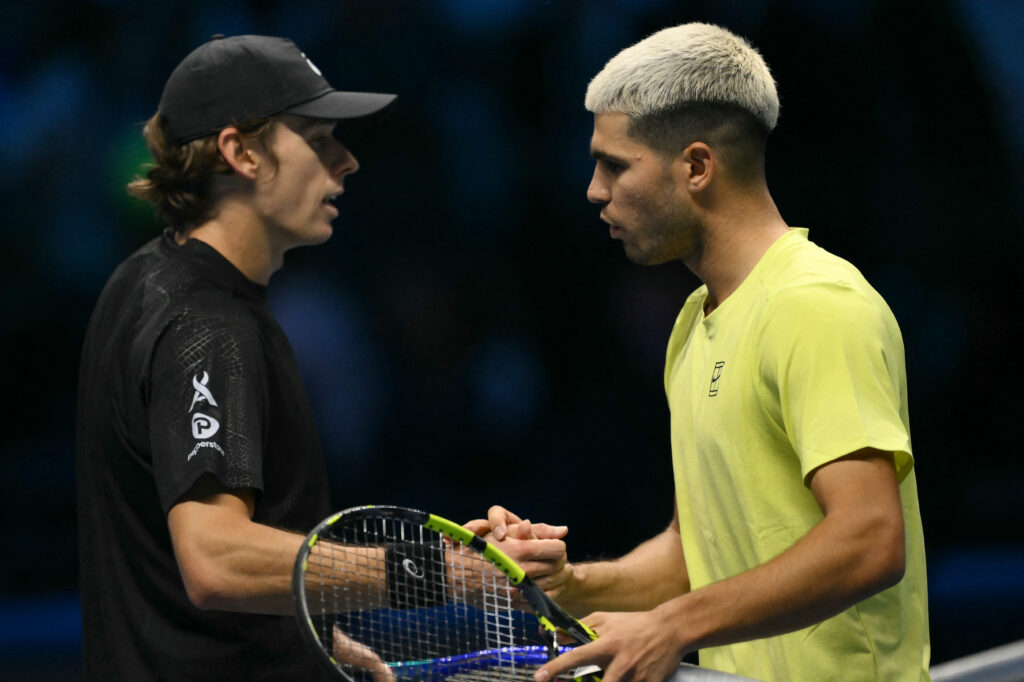 Spain's Carlos Alcaraz shakes hands with Australia's Alex De Minaur after winning the match at the ATP Finals tennis tournament in Turin on November 9, 2025.