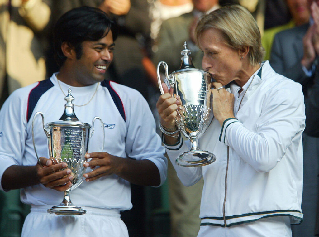 Martina Navratilova (R) of the US kisses her trophy as Leander Paes of India watches after they won their Mixed Doubles Final over Andy Ram of Israel and Anastassia Rodionova of Russia at the Wimbledon Tennis Championships 06 July, 2003 in Wimbledon, south London. Navratilova/Paes won 6-3, 6-3 and Navratilova won her 20th Wimbledon Championship title.