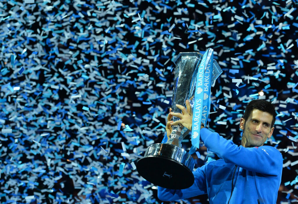 Serbia's Novak Djokovic holds up the ATP trophy after winning the men's singles final match against Switzerland's Roger Federer on day eight of the ATP World Tour Finals tennis tournament in London on November 22, 2015.