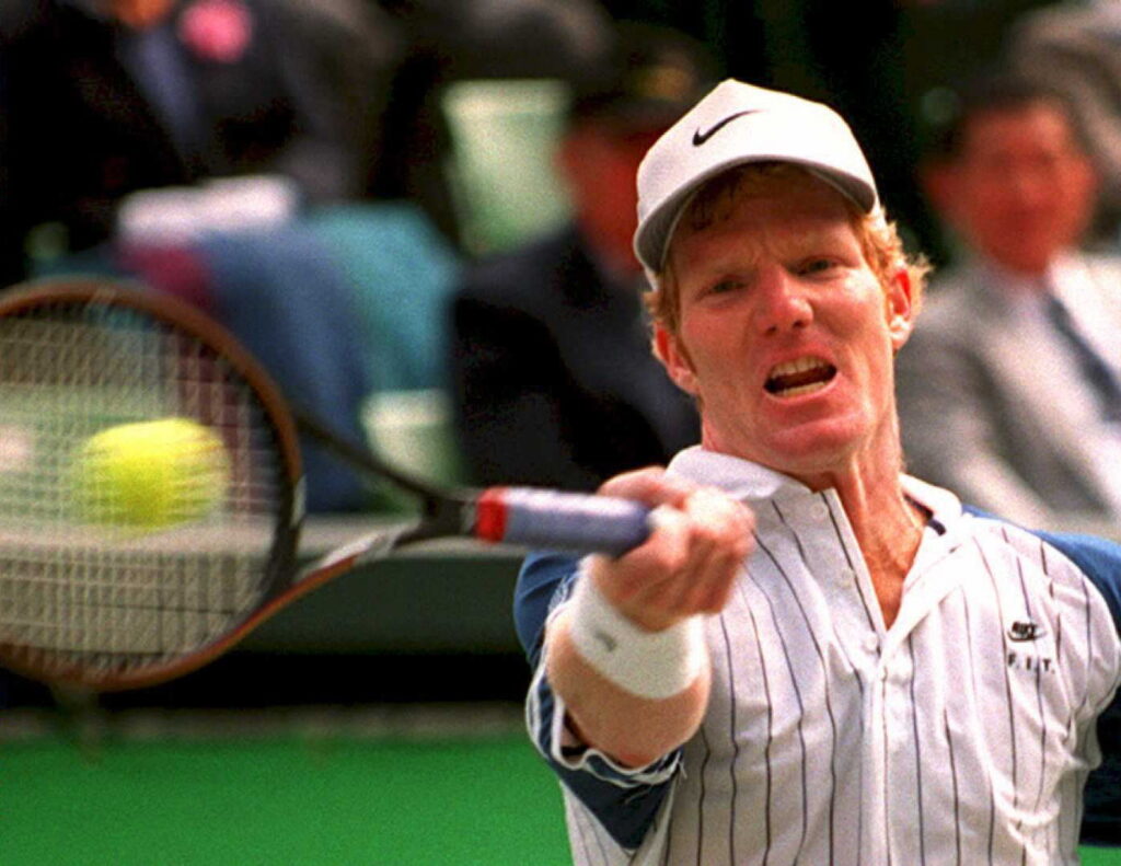 Former world number one Jim Courier hits a forehan