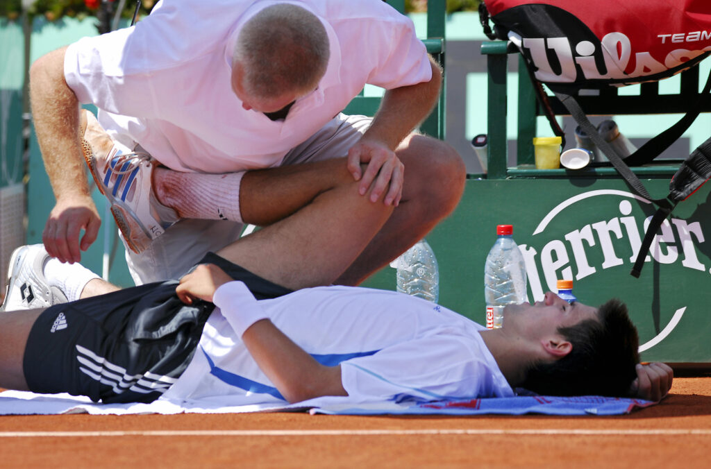 Serbia Montenegro's Novak Djokovic is treated by a doctor during his match against Spain's Rafael Nadal during the quarter-finals of the French tennis Open at Roland Garros in Paris 07 June 2006.