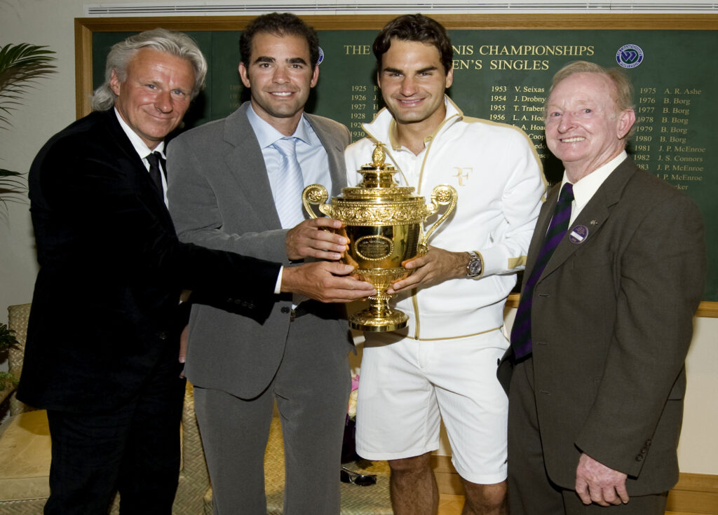 Roger Federer of Switzerland (2R) celebrates with the trophy alongside Bjorn Borg (L), Pete Sampras (2L) and Rod Laver (R) after the men's singles final match against Andy Roddick of USA on Day Thirteen of the Wimbledon Lawn Tennis Championships at the All England Lawn Tennis and Croquet Club on July 5, 2009 in London, England. Federer won 5-7, 7-6, 7-6, 3-6, 16-14, to claim his 15th Grand Slam title.