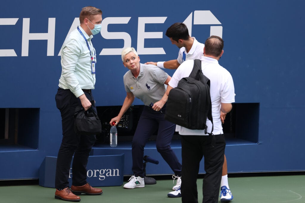 Novak Djokovic of Serbia tends to a lineswoman Laura Clark after inadvertently striking her with a ball hit in frustration during his Men's Singles fourth round match against Pablo Carreno Busta of Spain on Day Seven of the 2020 US Open at the USTA Billie Jean King National Tennis Center on September 6, 2020 in the Queens borough of New York City. Djokovic was defaulted from the match.