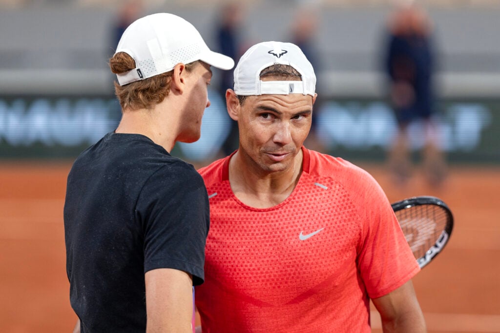 Rafael Nadal of Spain greets Jannik Sinner of Italy during training change over on Court Philippe-Chatrier as they practice in preparation for the 2024 French Open Tennis Tournament at Roland Garros on May 22nd, 2024, in Paris, France.